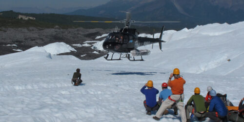 a group of people standing on top of a snow covered mountain