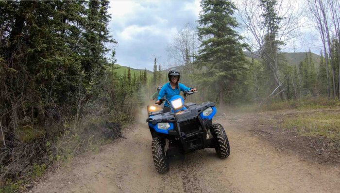 Thrill-seeker navigating a muddy trail on an ATV during an Alaska adventure tour