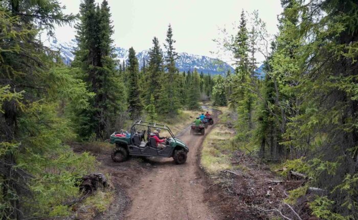 Thrill-seekers on an Alaska ATV adventure surrounded by breathtaking landscapes