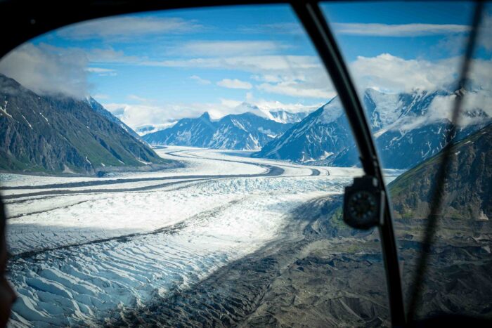 Helicopter soaring over stunning Alaskan glaciers on a scenic adventure.